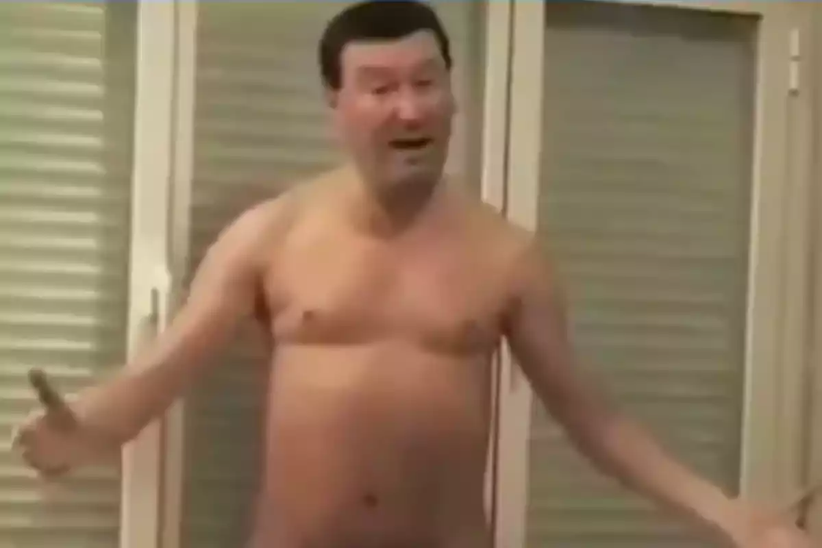 Hombre de pie sin camisa gesticulando con los brazos abiertos frente a unas ventanas con persianas cerradas Hombre de pie sin camisa gesticulando con los brazos abiertos frente a unas ventanas con persianas cerradas