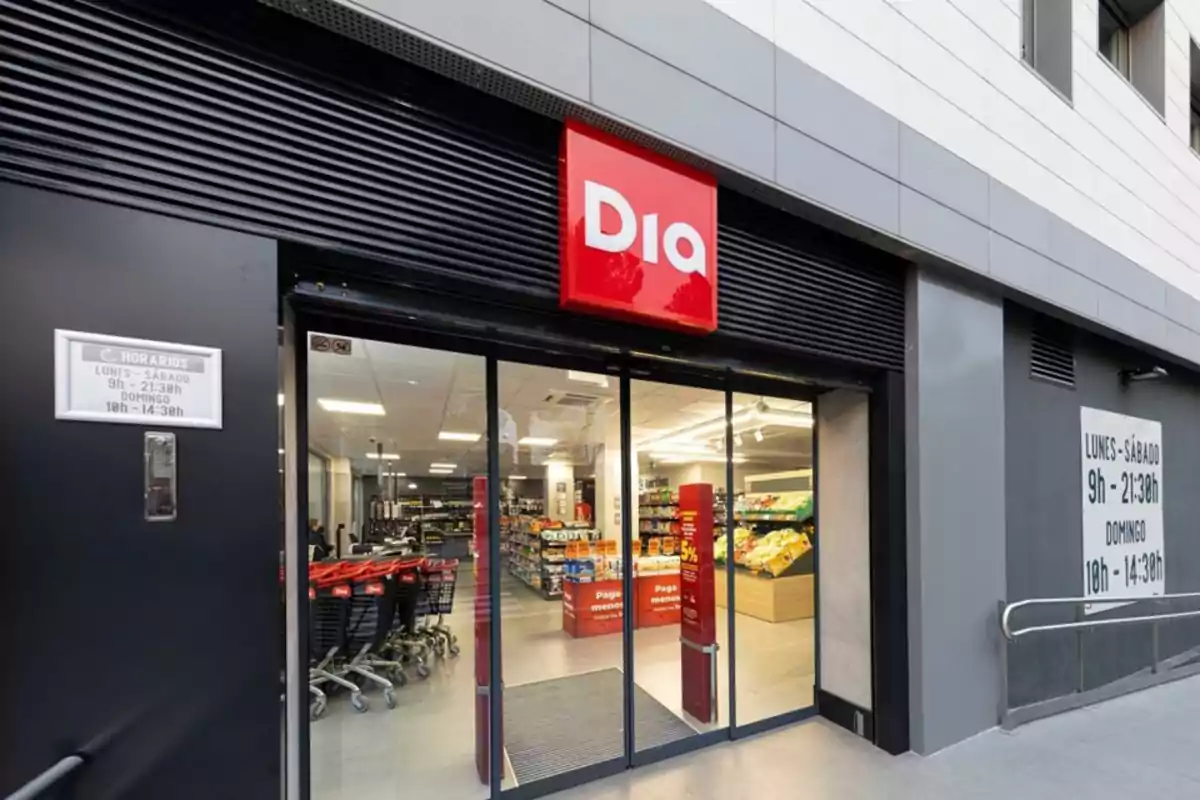 Fachada de un supermercado Dia con puertas de cristal abiertas y carros de la compra en la entrada Fachada de un supermercado Dia con puertas de cristal abiertas y carros de la compra en la entrada