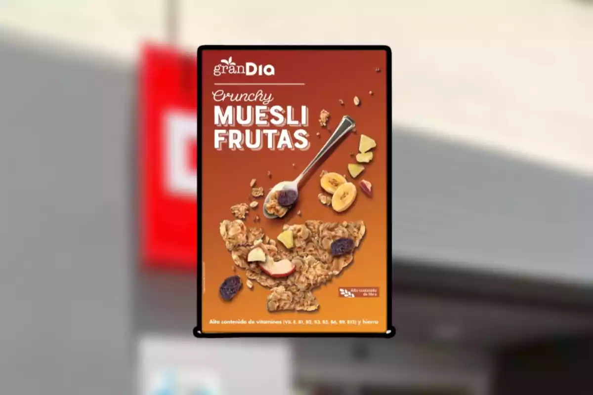 Cartel publicitario de granola muesli con frutas de la marca granDia sobre fondo naranja con una cuchara y trozos de fruta deshidratada Cartel publicitario de granola muesli con frutas de la marca granDia sobre fondo naranja con una cuchara y trozos de fruta deshidratada