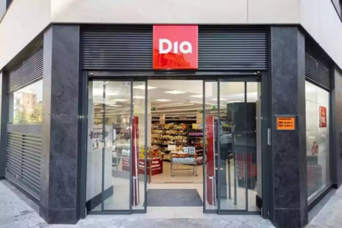 Fachada de un supermercado Dia con puertas de cristal abiertas y estantes de productos visibles en el interior Fachada de un supermercado Dia con puertas de cristal abiertas y estantes de productos visibles en el interior