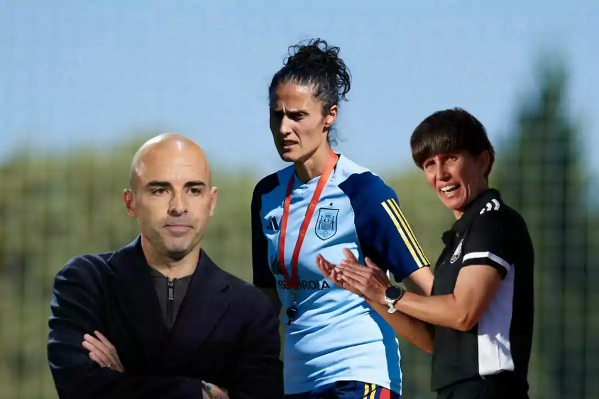 Tres personas relacionadas con el fútbol aparecen en primer plano, una de ellas lleva un uniforme deportivo de la selección de España y las otras dos visten ropa de entrenador, con un fondo desenfocado de campo deportivo.