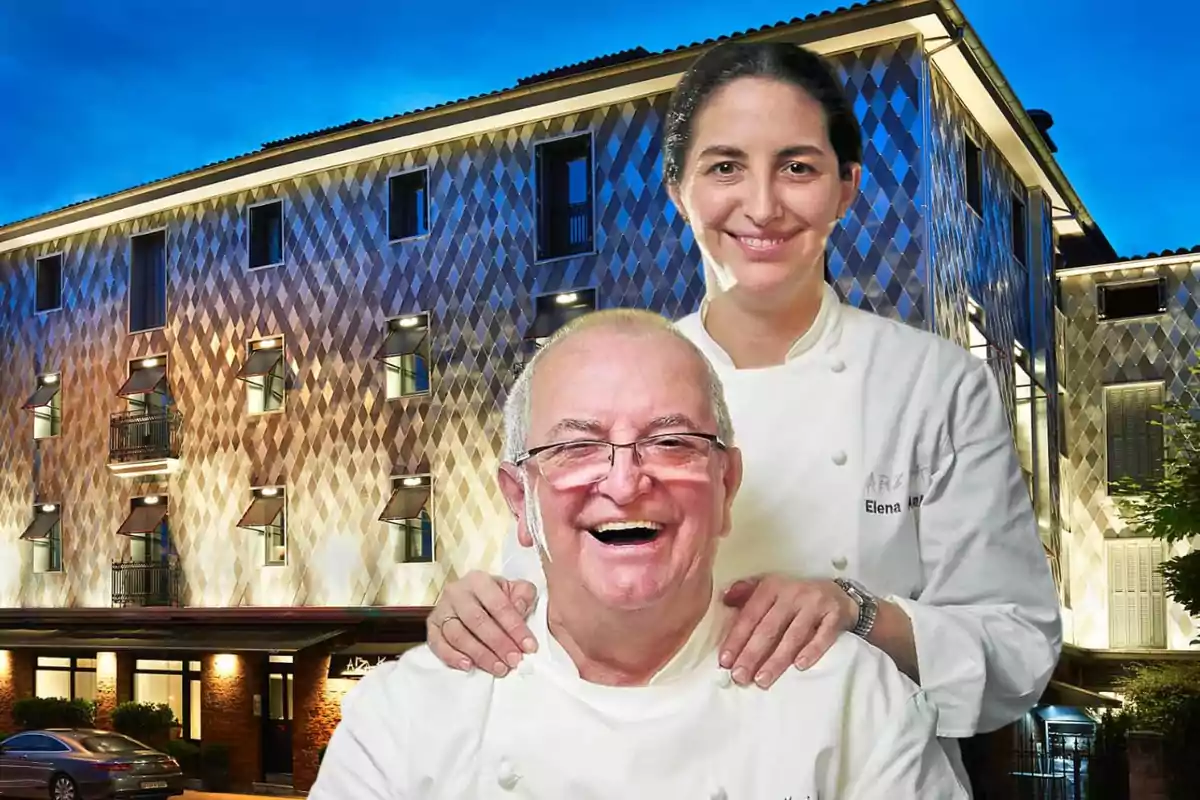 Dos chefs sonrientes con uniforme blanco posan frente a un edificio moderno iluminado al anochecer Dos chefs sonrientes con uniforme blanco posan frente a un edificio moderno iluminado al anochecer