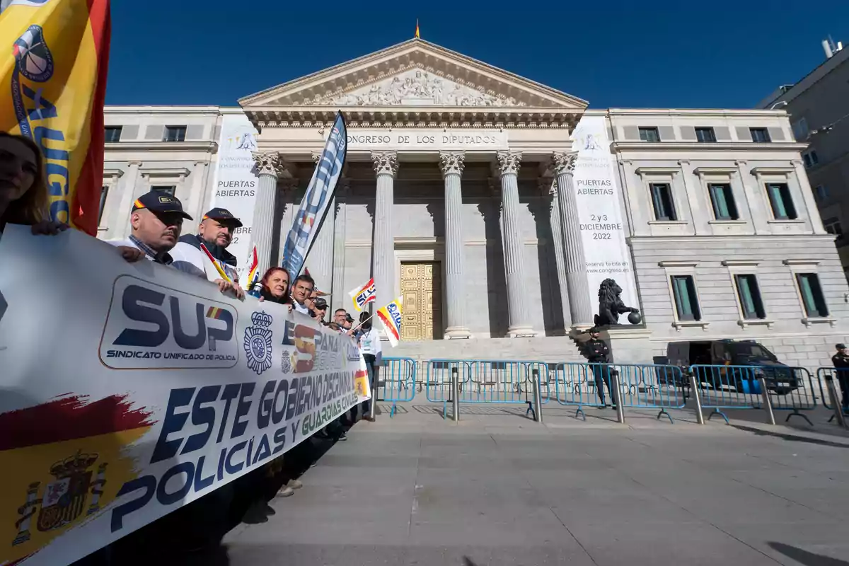 Manifestación de policías y guardias civiles frente al Congreso de los Diputados en Madrid con pancartas y banderas bajo un cielo despejado Manifestación de policías y guardias civiles frente al Congreso de los Diputados en Madrid con pancartas y banderas bajo un cielo despejado