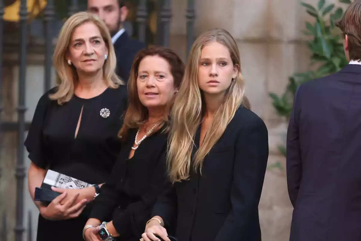 Tres mujeres vestidas de negro con expresión seria están de pie en un evento formal al aire libre Tres mujeres vestidas de negro con expresión seria están de pie en un evento formal al aire libre