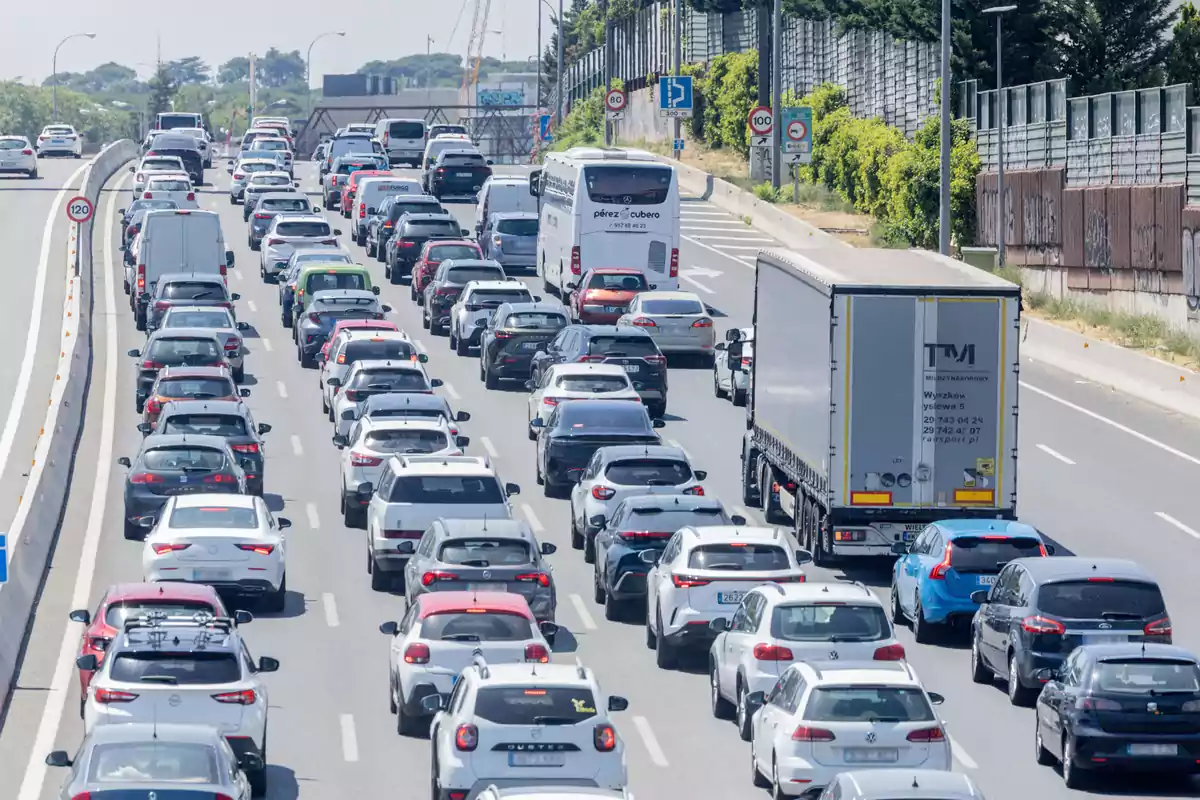 Carretera con tráfico denso de automóviles, camiones y autobuses en varios carriles durante el día