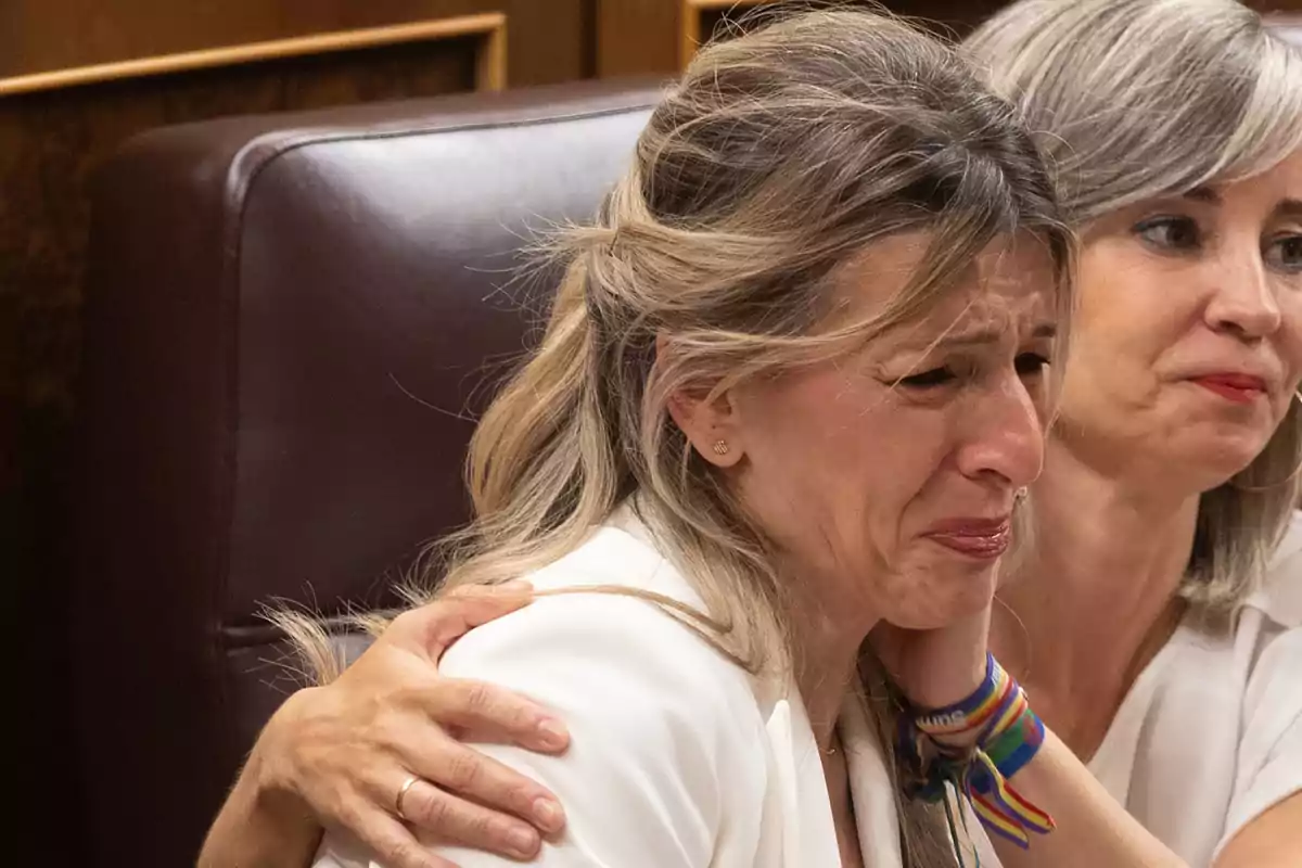 Mujer visiblemente emocionada y llorando mientras es consolada por otra mujer que la abraza Mujer visiblemente emocionada y llorando mientras es consolada por otra mujer que la abraza