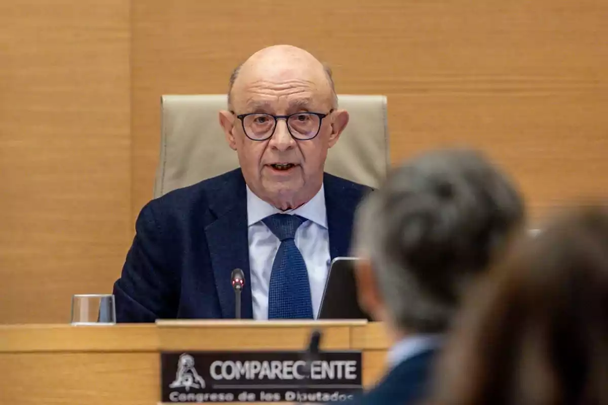 Hombre mayor con gafas y traje azul hablando en una comparecencia en el Congreso de los Diputados