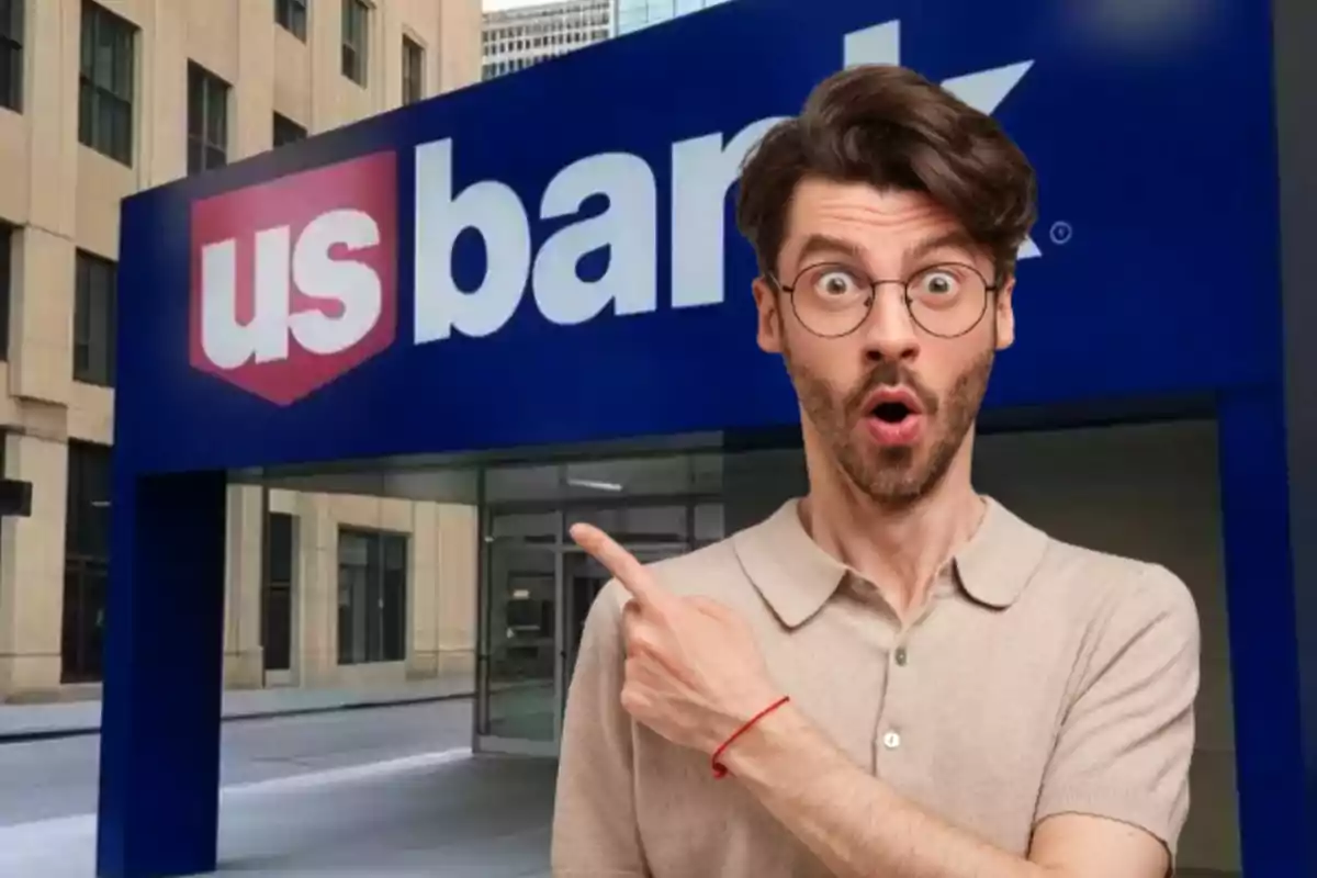 Hombre con expresión de sorpresa y señalando hacia el letrero de un banco US Bank en la entrada de un edificio Hombre con expresión de sorpresa y señalando hacia el letrero de un banco US Bank en la entrada de un edificio