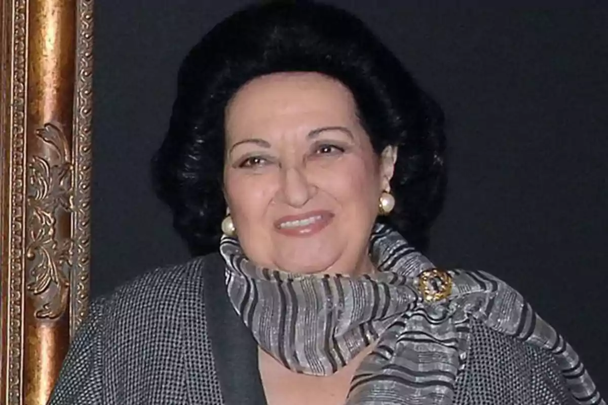 Mujer de cabello oscuro y peinado voluminoso, con pendientes de perla y bufanda gris con broche, sonriendo frente a un fondo oscuro Mujer de cabello oscuro y peinado voluminoso, con pendientes de perla y bufanda gris con broche, sonriendo frente a un fondo oscuro