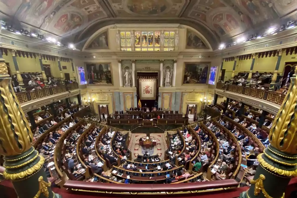 Vista panorámica del hemiciclo del Congreso de los Diputados de España durante una sesión parlamentaria con los escaños ocupados y la mesa presidencial al fondo Vista panorámica del hemiciclo del Congreso de los Diputados de España durante una sesión parlamentaria con los escaños ocupados y la mesa presidencial al fondo