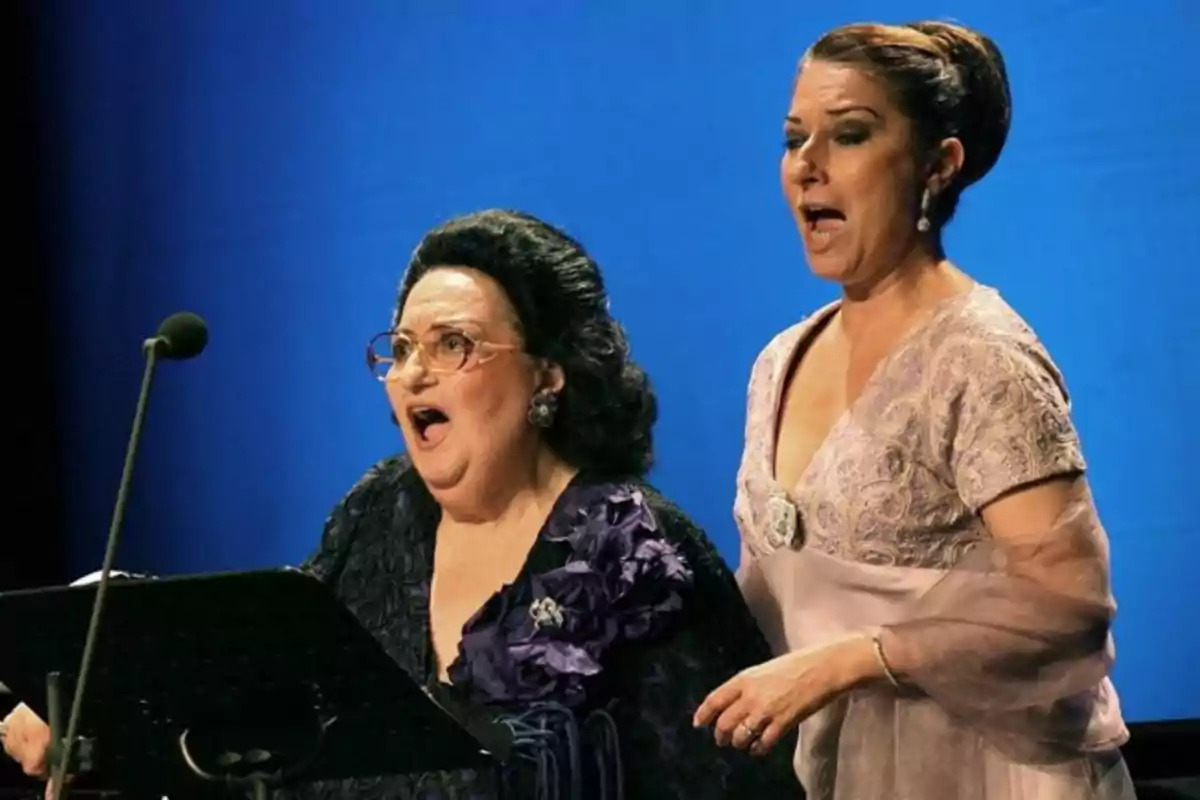 Dos mujeres elegantemente vestidas cantan en un escenario frente a un micrófono con fondo azul Dos mujeres elegantemente vestidas cantan en un escenario frente a un micrófono con fondo azul