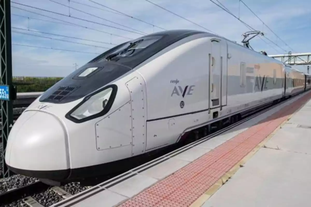 Tren de alta velocidad AVE detenido en una estación bajo un cielo despejado Tren de alta velocidad AVE detenido en una estación bajo un cielo despejado