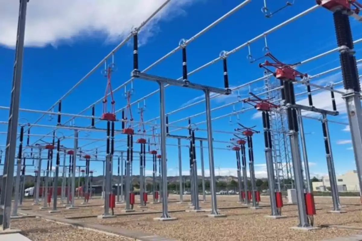 Subestación eléctrica al aire libre con estructuras metálicas y equipos de alta tensión bajo un cielo azul Subestación eléctrica al aire libre con estructuras metálicas y equipos de alta tensión bajo un cielo azul