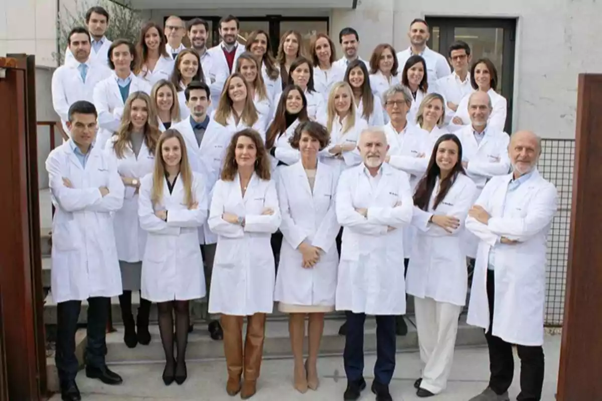 Grupo de profesionales de la salud posando juntos al aire libre con batas blancas Grupo de profesionales de la salud posando juntos al aire libre con batas blancas