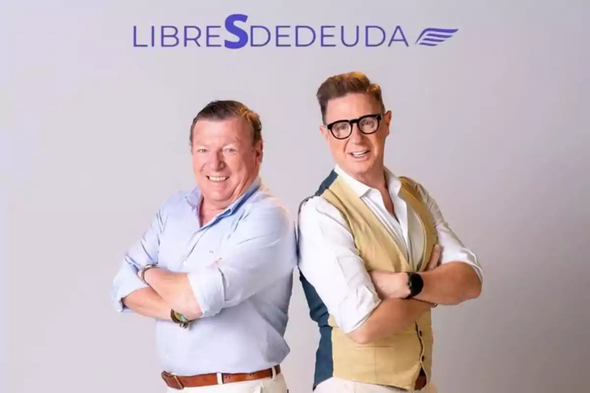 Dos hombres sonrientes posan de pie con los brazos cruzados frente a un fondo claro con el texto LIBRES DE DEUDA arriba de ellos