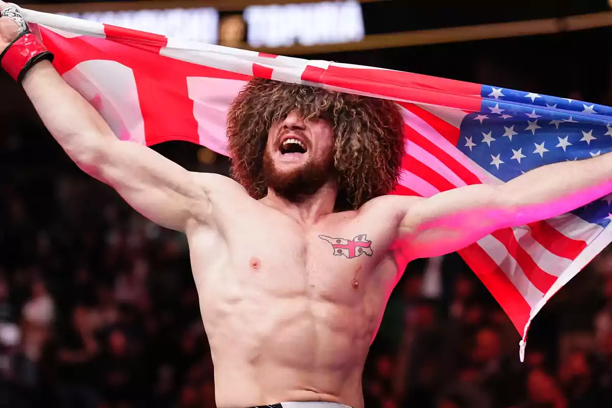 Luchador celebrando con una bandera de Estados Unidos sobre los hombros y usando un gorro tradicional de lana Luchador celebrando con una bandera de Estados Unidos sobre los hombros y usando un gorro tradicional de lana