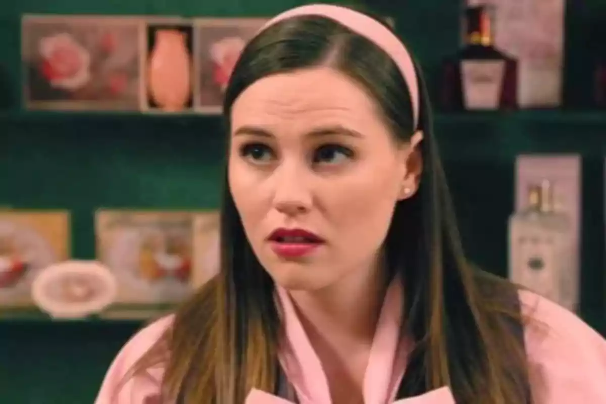 Isabel Moreno joven con diadema rosa y bata rosa en una tienda de perfumes y cosméticos Isabel Moreno joven con diadema rosa y bata rosa en una tienda de perfumes y cosméticos