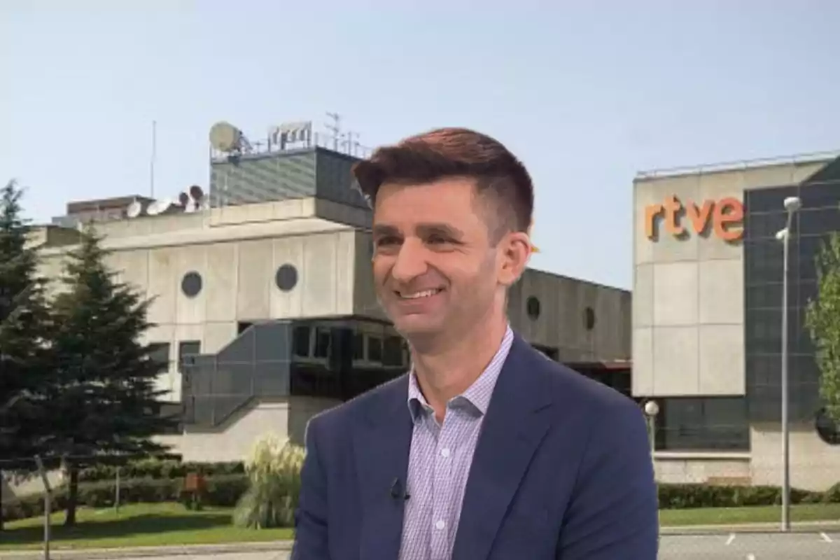 Hombre sonriente con chaqueta azul frente a un edificio de RTVE