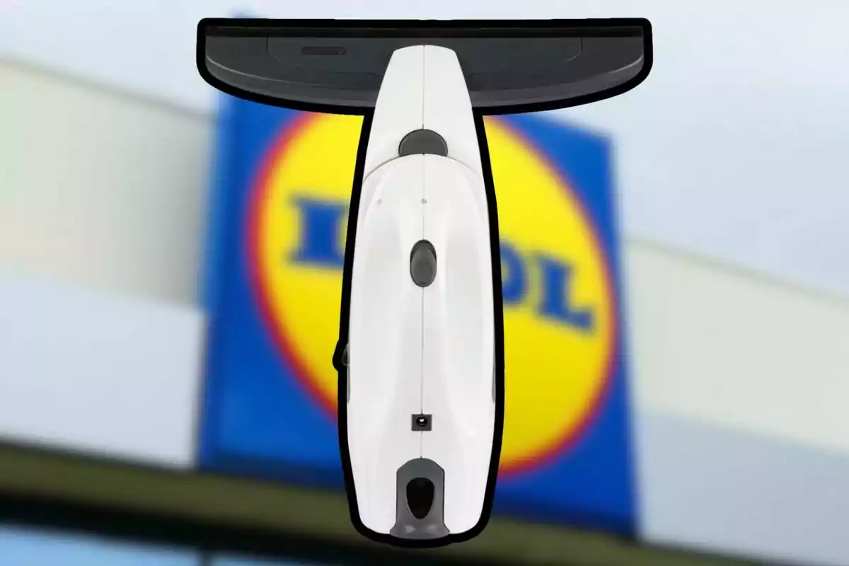 Limpiacristales eléctrico de color blanco y negro con fondo desenfocado de un cartel de supermercado Limpiacristales eléctrico de color blanco y negro con fondo desenfocado de un cartel de supermercado