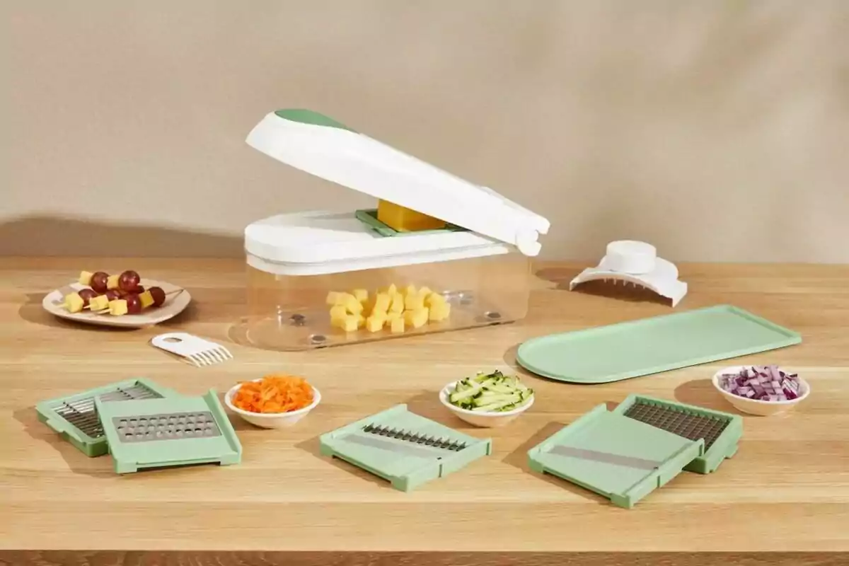 Cortador de verduras multifuncional con varios accesorios y platos pequeños con alimentos picados sobre una mesa de madera Cortador de verduras multifuncional con varios accesorios y platos pequeños con alimentos picados sobre una mesa de madera