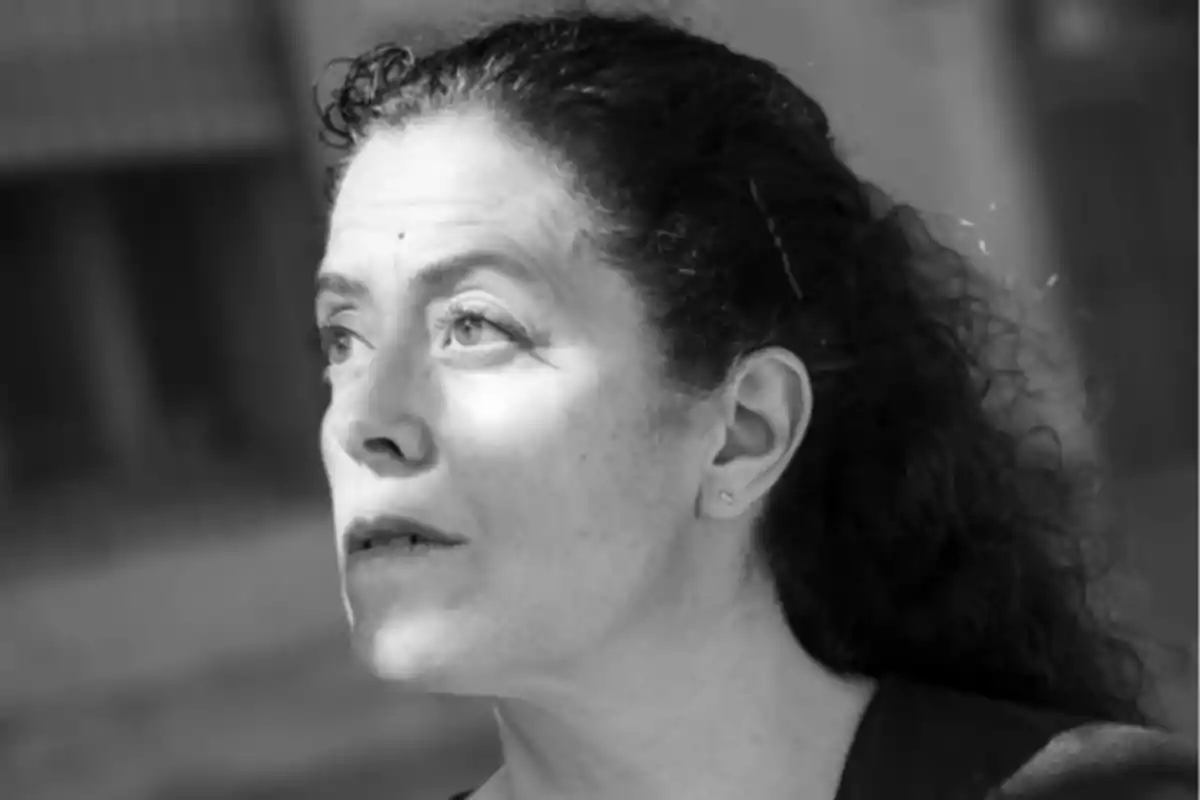 Mujer de cabello rizado y oscuro mirando hacia arriba en una imagen en blanco y negro Mujer de cabello rizado y oscuro mirando hacia arriba en una imagen en blanco y negro