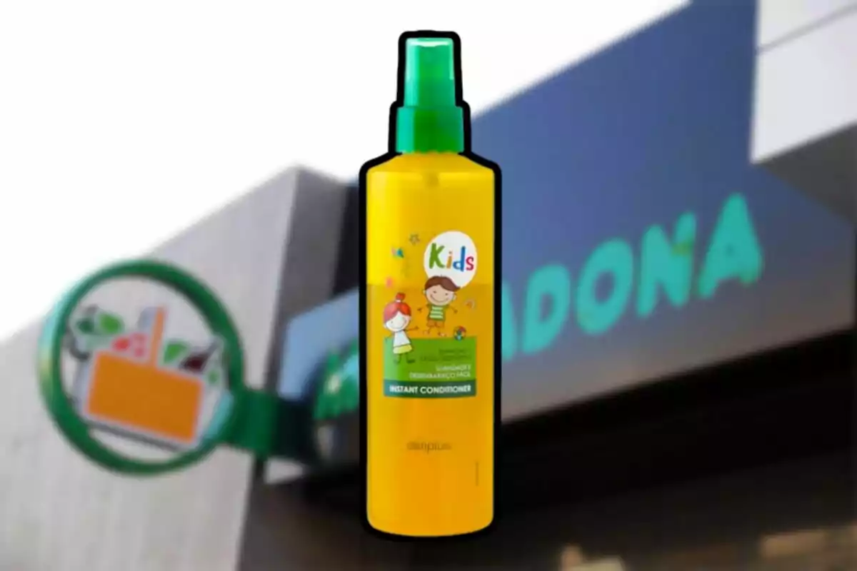 Botella amarilla de acondicionador infantil Deliplus Kids frente a una tienda Mercadona desenfocada Botella amarilla de acondicionador infantil Deliplus Kids frente a una tienda Mercadona desenfocada