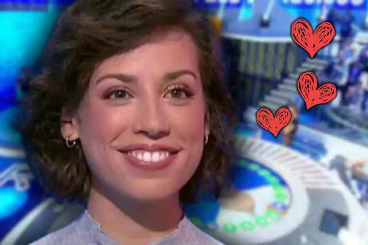 Rosa de cabello corto y rizado sonriendo frente a un fondo de 'Pasapalabra' con tres corazones rojos dibujados a la derecha