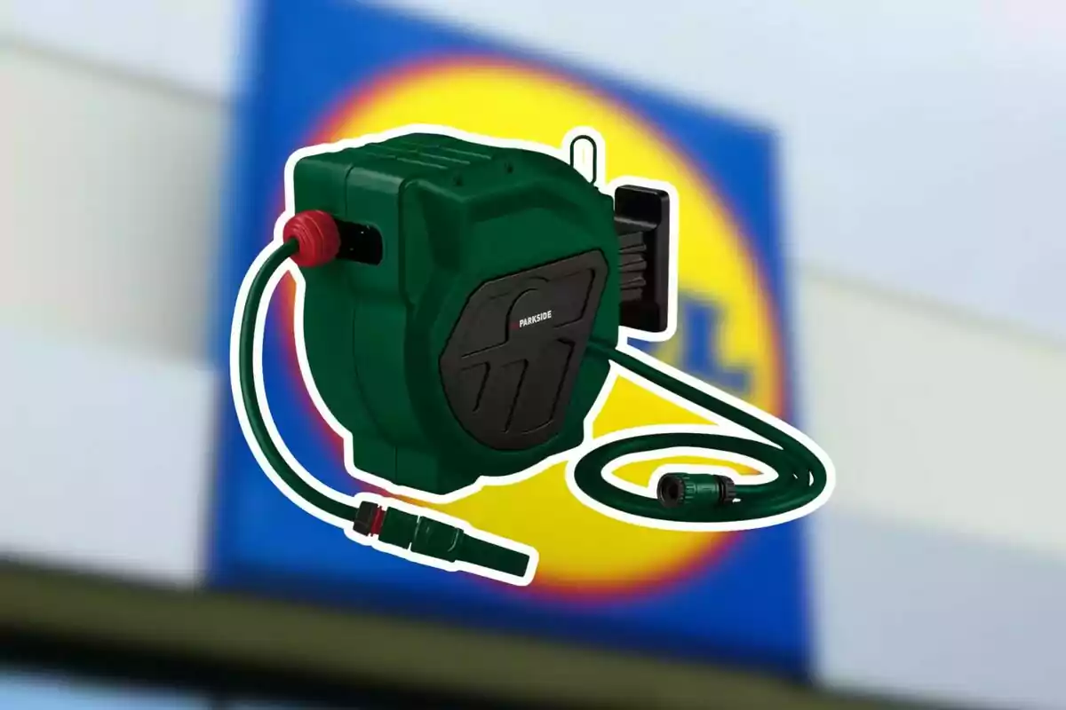 Carrete enrollador de manguera verde de la marca Parkside frente a un cartel borroso de Lidl Carrete enrollador de manguera verde de la marca Parkside frente a un cartel borroso de Lidl