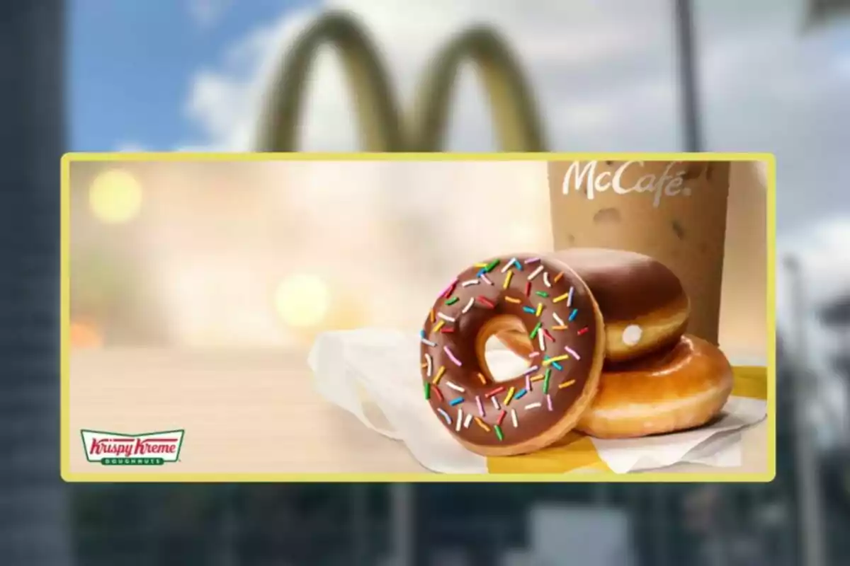 Tres donas Krispy Kreme, una con chocolate y chispas de colores, junto a un café helado de McCafé sobre una mesa con fondo desenfocado de McDonald's. Tres donas Krispy Kreme, una con chocolate y chispas de colores, junto a un café helado de McCafé sobre una mesa con fondo desenfocado de McDonald's.