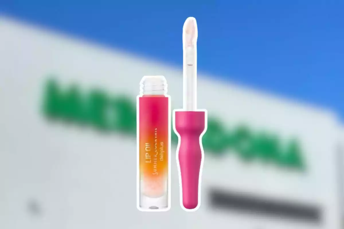 Un brillo labial con aplicador rosa y envase degradado en tonos naranja y rosa sobre un fondo desenfocado de una tienda Un brillo labial con aplicador rosa y envase degradado en tonos naranja y rosa sobre un fondo desenfocado de una tienda