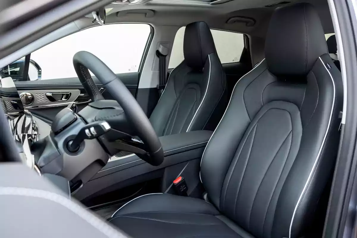 Interior de un automóvil moderno con asientos de cuero negro y detalles elegantes en el tablero Interior de un automóvil moderno con asientos de cuero negro y detalles elegantes en el tablero