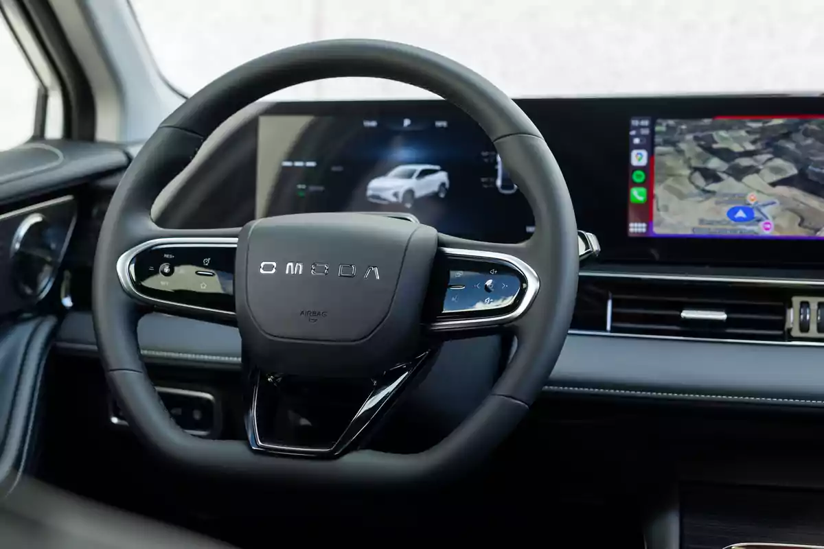 Volante de un automóvil Omoda con pantallas digitales en el tablero mostrando información del vehículo y navegación. Volante de un automóvil Omoda con pantallas digitales en el tablero mostrando información del vehículo y navegación.