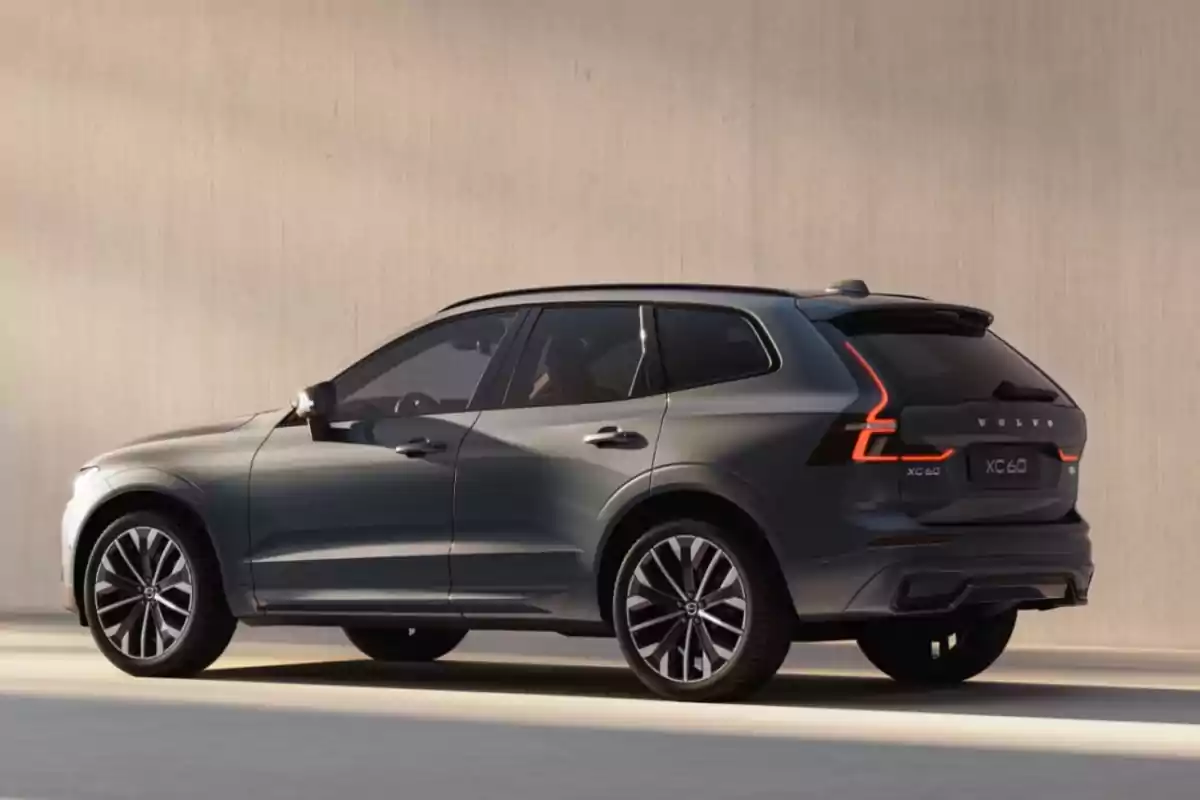 SUV Volvo XC60 gris estacionada junto a una pared beige SUV Volvo XC60 gris estacionada junto a una pared beige