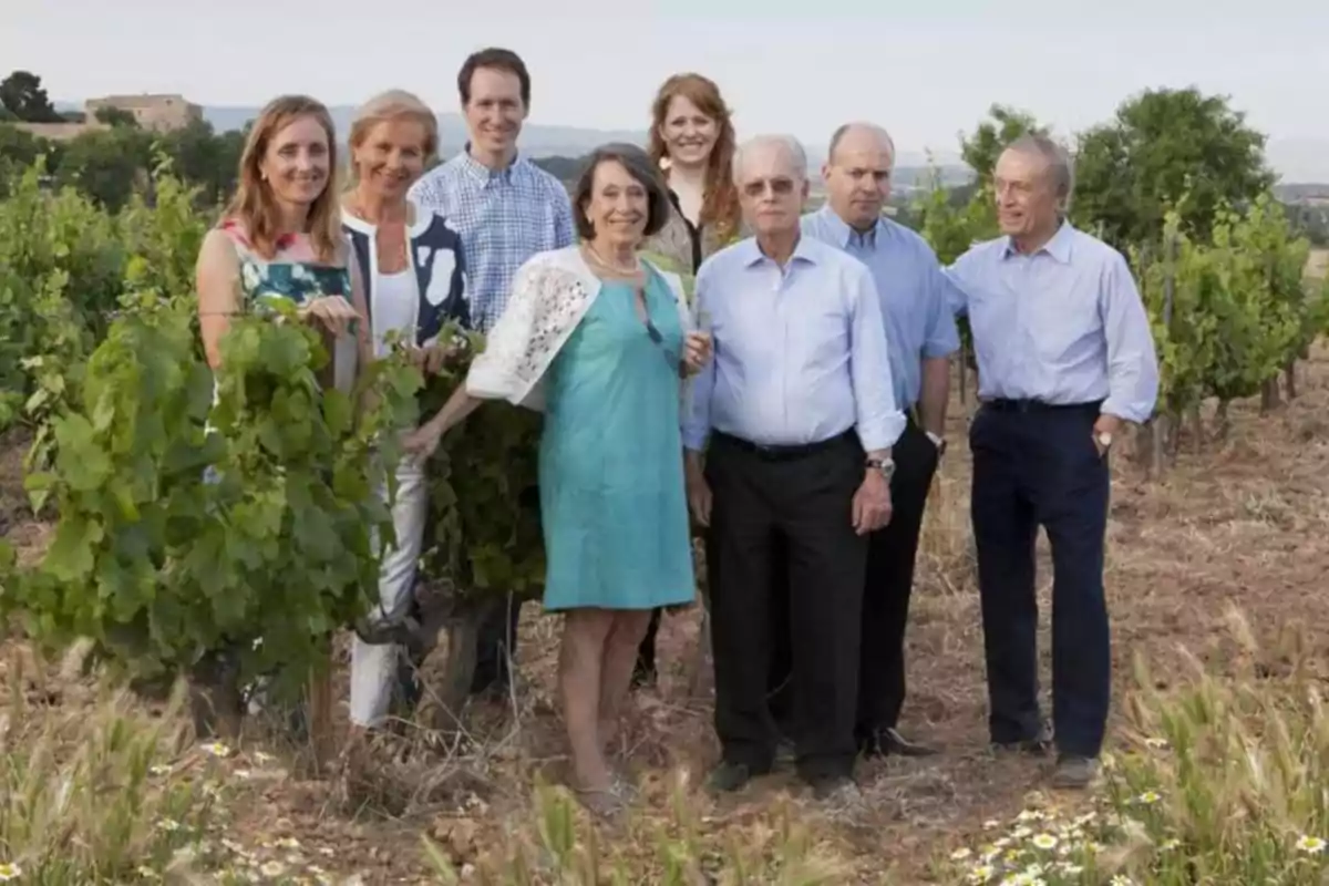 Un grupo de personas posando juntas en un viñedo rodeados de plantas y naturaleza Un grupo de personas posando juntas en un viñedo rodeados de plantas y naturaleza