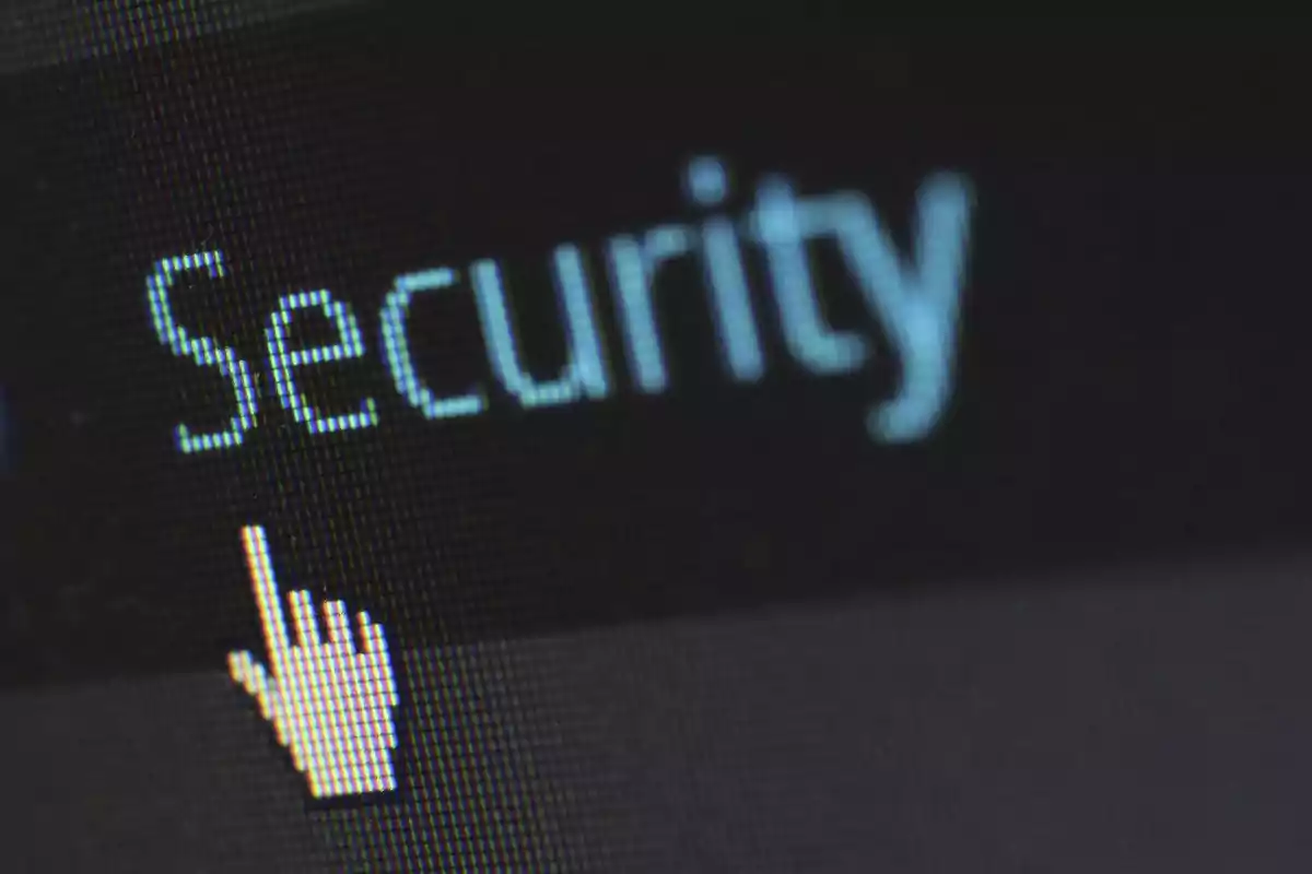 Pantalla de computadora con la palabra Security y un cursor en forma de mano señalando el texto