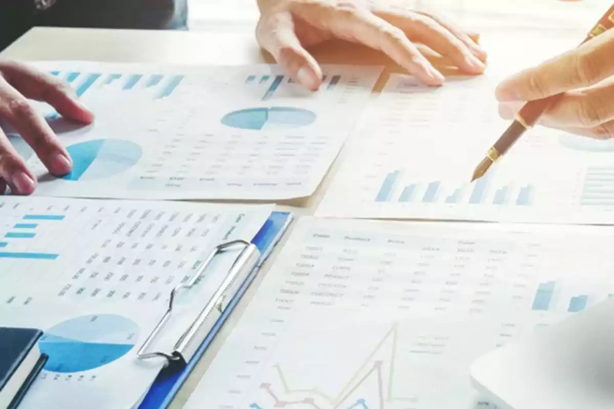 Personas revisando y analizando gráficos y documentos financieros sobre una mesa