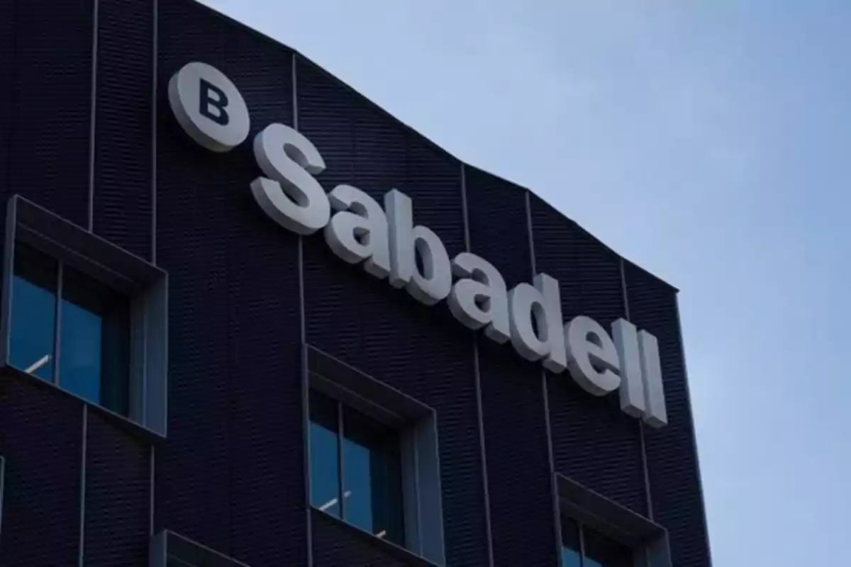 Edificio moderno con el logotipo de Sabadell en la fachada bajo un cielo despejado Edificio moderno con el logotipo de Sabadell en la fachada bajo un cielo despejado