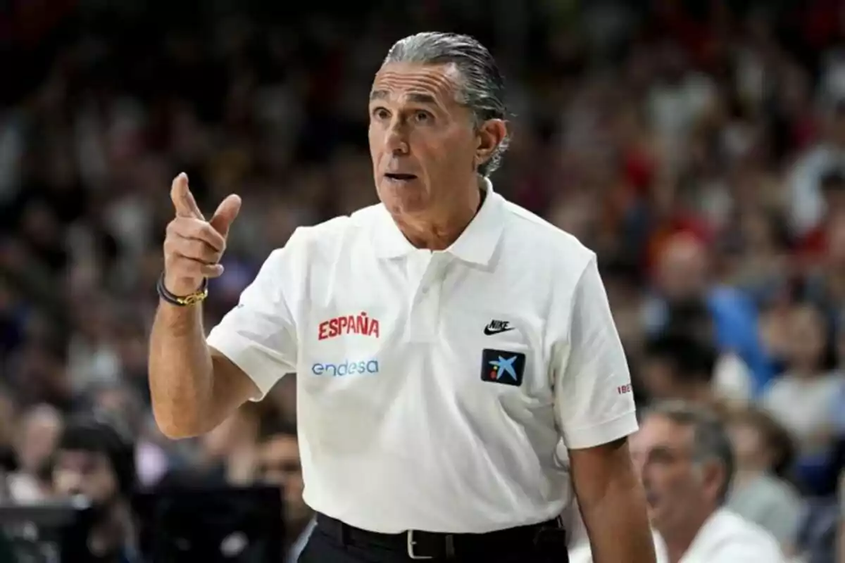 Entrenador de baloncesto con camiseta blanca de España dando indicaciones durante un partido Entrenador de baloncesto con camiseta blanca de España dando indicaciones durante un partido