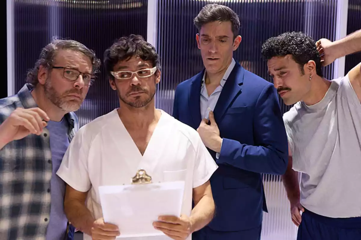 Cuatro hombres observan atentamente unos papeles que sostiene uno de ellos vestido con bata blanca mientras los otros tres muestran expresiones de curiosidad y concentración