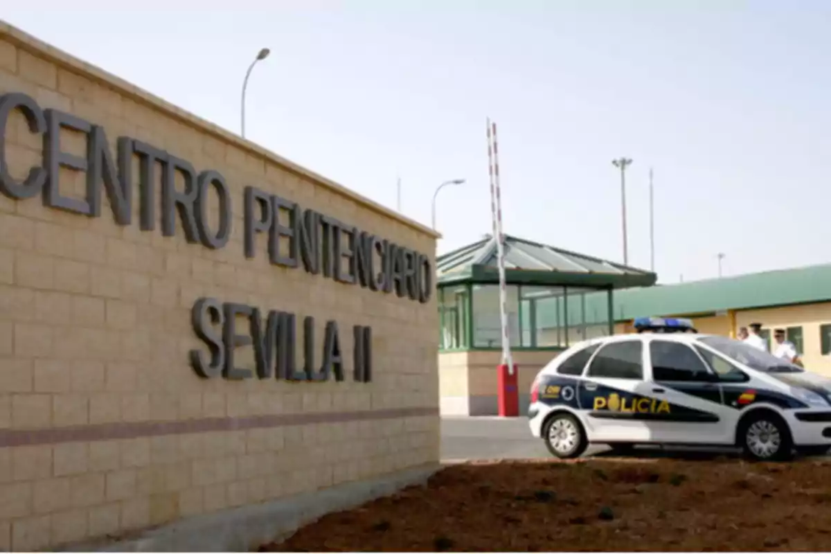 Fachada del Centro Penitenciario Sevilla II con un coche de policía estacionado en la entrada
