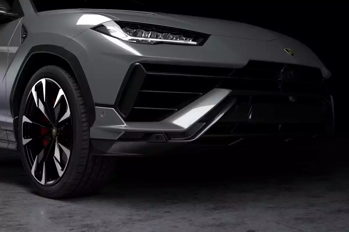 Parte frontal de un automóvil deportivo gris con diseño agresivo y llanta de aleación negra y plateada Parte frontal de un automóvil deportivo gris con diseño agresivo y llanta de aleación negra y plateada