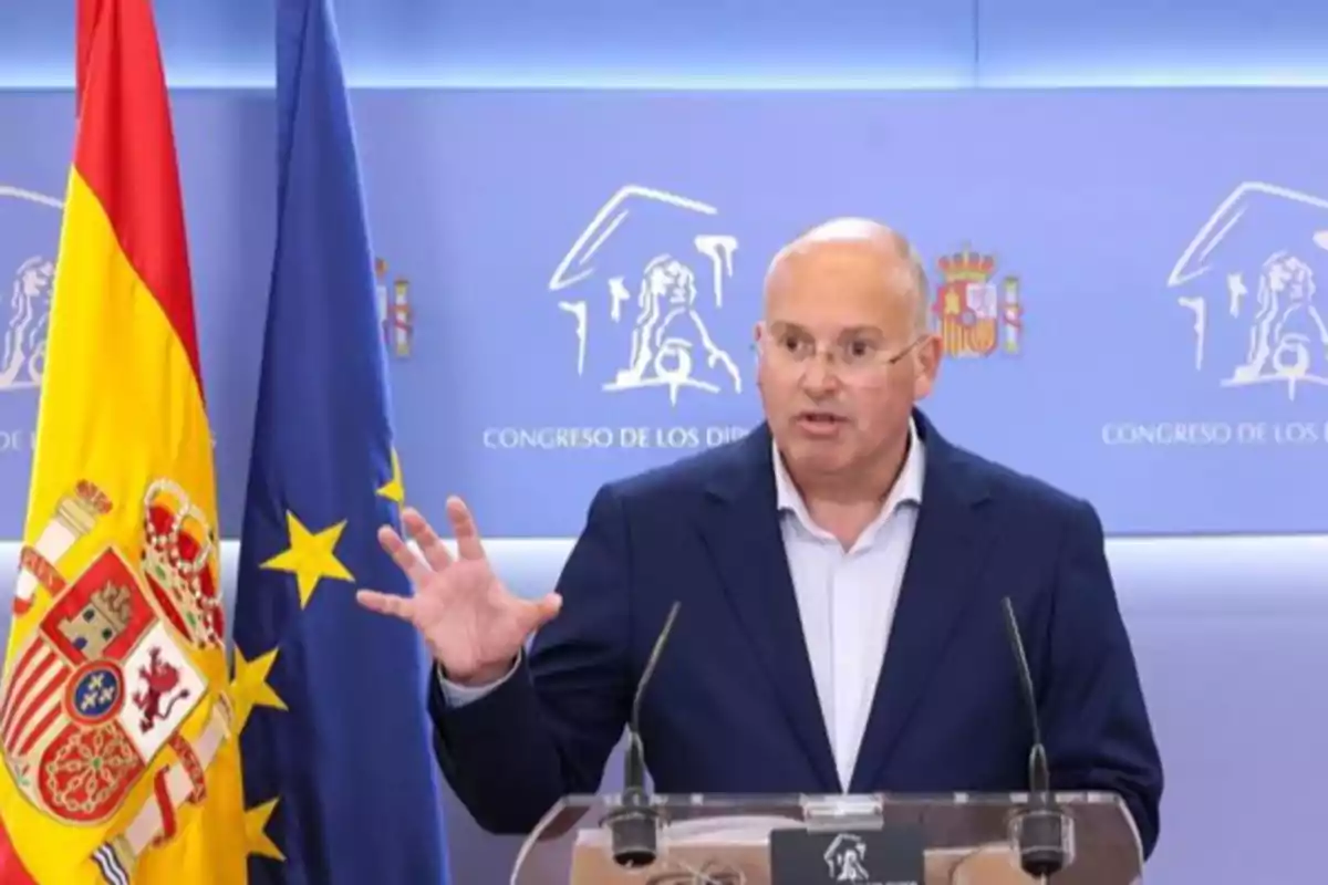 Hombre calvo con gafas hablando en una rueda de prensa en el Congreso de los Diputados junto a las banderas de España y la Unión Europea Hombre calvo con gafas hablando en una rueda de prensa en el Congreso de los Diputados junto a las banderas de España y la Unión Europea