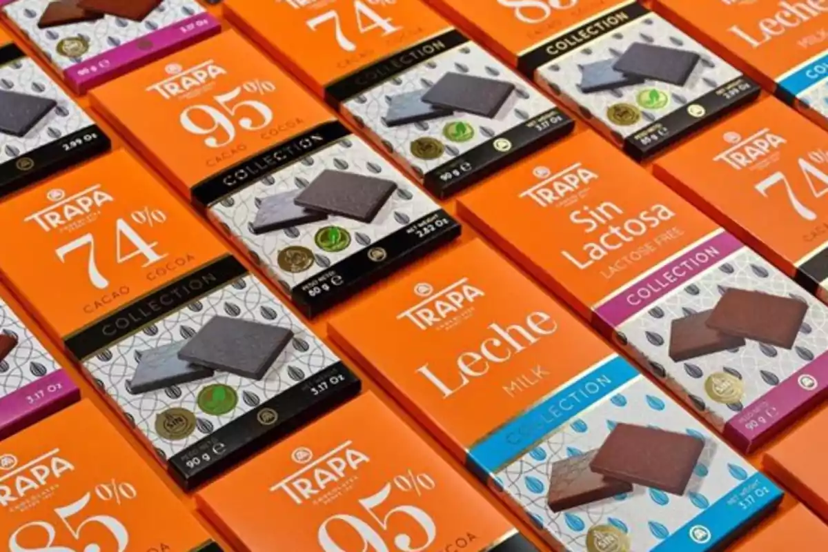 Varias tabletas de chocolate Trapa en diferentes presentaciones y porcentajes de cacao dispuestas en filas sobre una superficie Varias tabletas de chocolate Trapa en diferentes presentaciones y porcentajes de cacao dispuestas en filas sobre una superficie