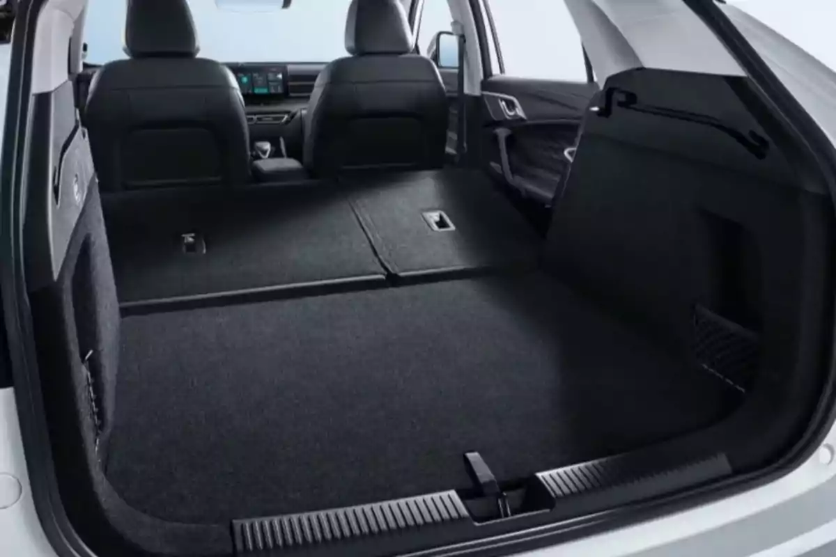 Vista del interior de la cajuela de un automóvil con los asientos traseros abatidos mostrando un espacio amplio para carga Vista del interior de la cajuela de un automóvil con los asientos traseros abatidos mostrando un espacio amplio para carga