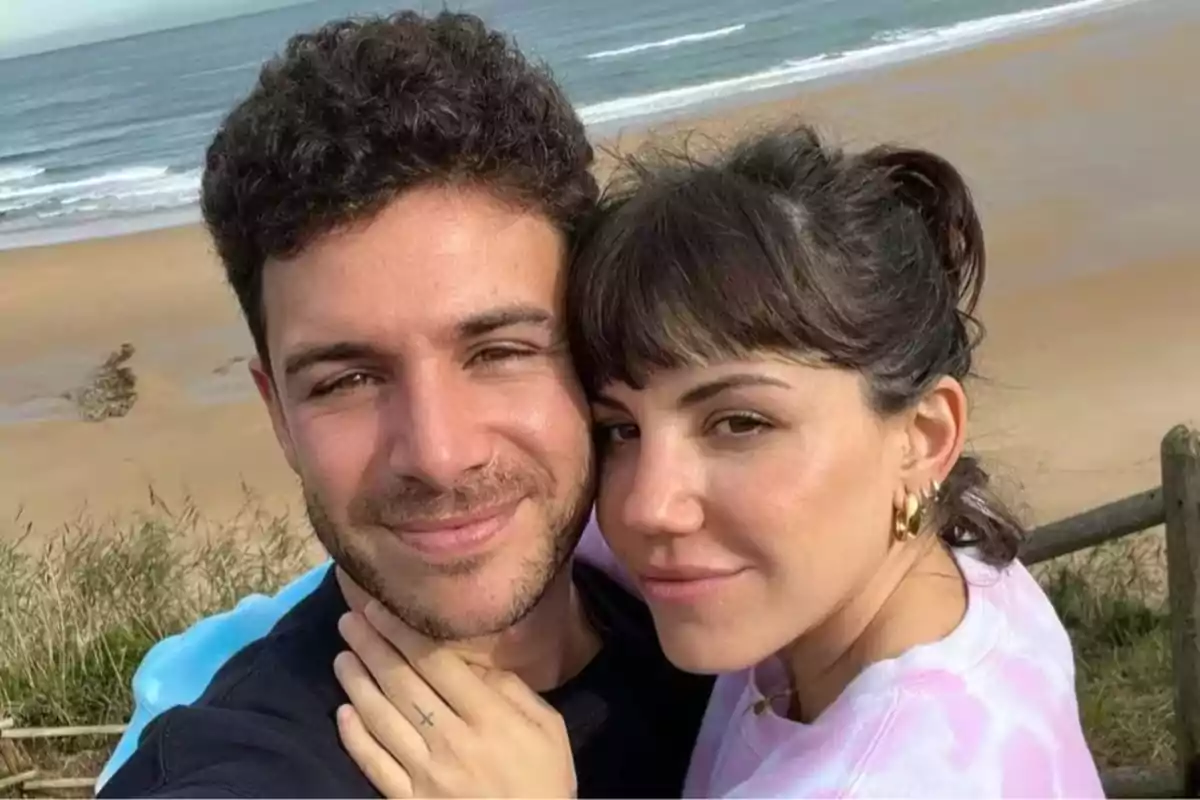 Pareja joven tomándose una selfie en la playa con el mar de fondo Pareja joven tomándose una selfie en la playa con el mar de fondo