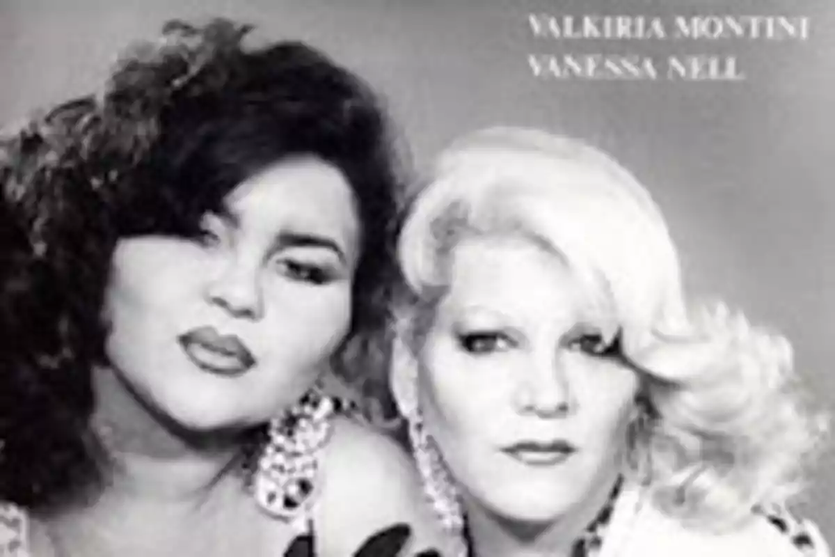 Dos personas posan juntas en una fotografía en blanco y negro, ambas con peinados voluminosos y maquillaje llamativo Dos personas posan juntas en una fotografía en blanco y negro, ambas con peinados voluminosos y maquillaje llamativo