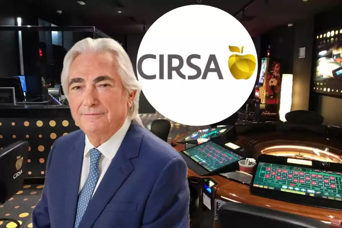 Hombre de cabello canoso con traje azul posando en un casino con mesas de juego electrónicas y el logo de CIRSA al fondo