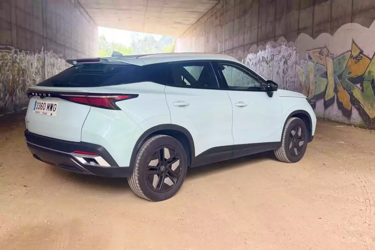 Un coche SUV blanco estacionado bajo un puente con paredes cubiertas de grafitis Un coche SUV blanco estacionado bajo un puente con paredes cubiertas de grafitis