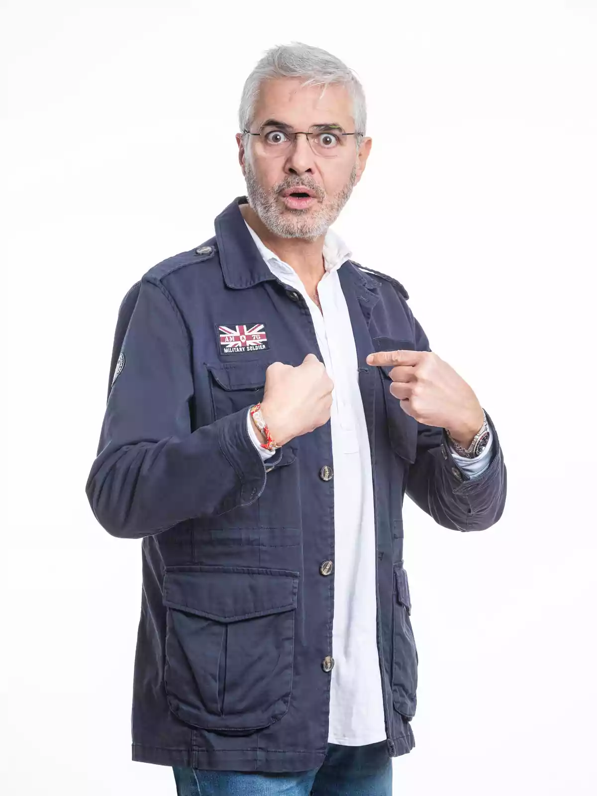 Hombre de cabello canoso y gafas con expresión de sorpresa señalándose a sí mismo con ambas manos Hombre de cabello canoso y gafas con expresión de sorpresa señalándose a sí mismo con ambas manos