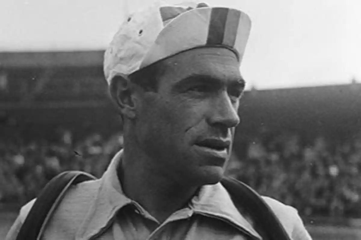 Hombre con gorra deportiva y uniforme en un estadio lleno de espectadores Hombre con gorra deportiva y uniforme en un estadio lleno de espectadores
